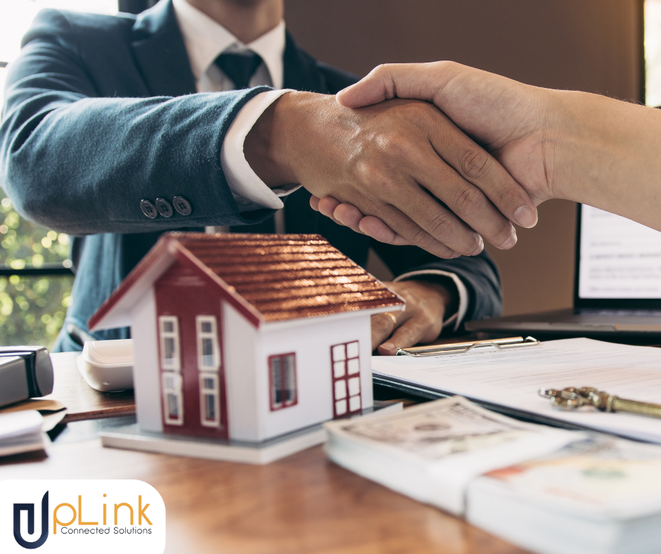 people shaking hands with a small house model